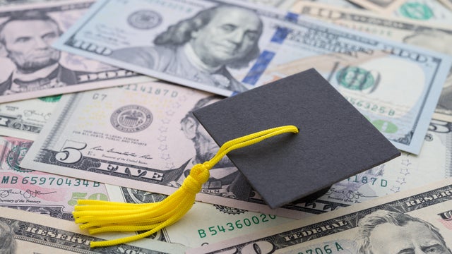 Graduation cap university or college degree on US dollars banknotes background. 